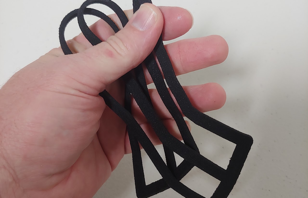 Technician flexing black dyed TPC elastomer part to show expectations for durability and consistent color