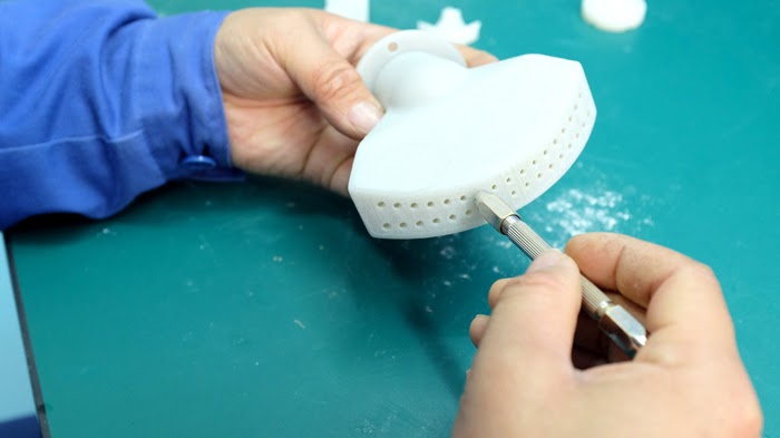 Technician cleaning SLS part to create Standard Finish with clean powder free surface